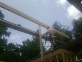 Carpenter setting a ridge beam over a new addition frame — Ice Dam Removal by Roofing Brothers in Atwood