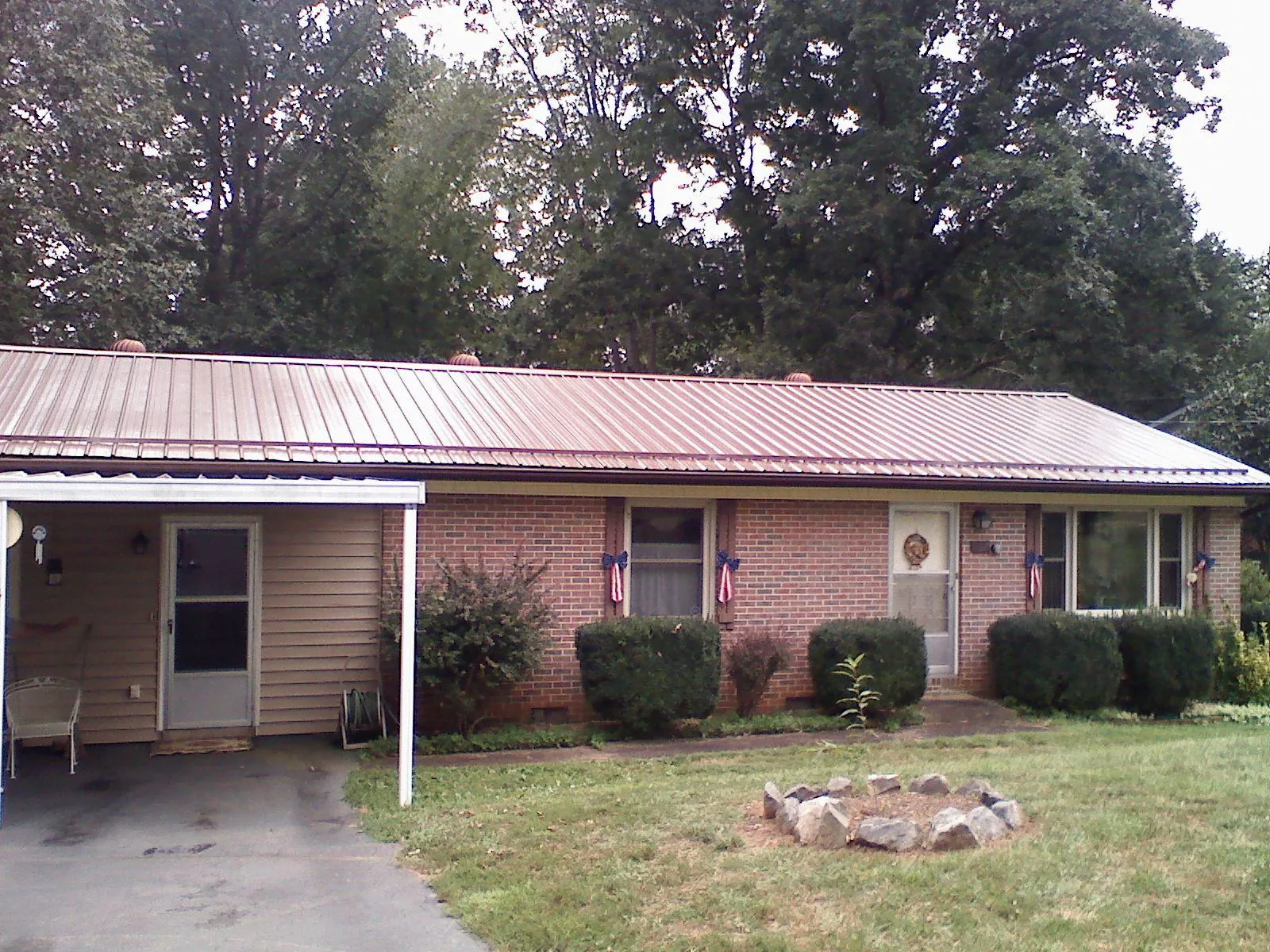 Bronze metal roof and carport on a brick ranch home — Roof Repair work by our crew in Atwood